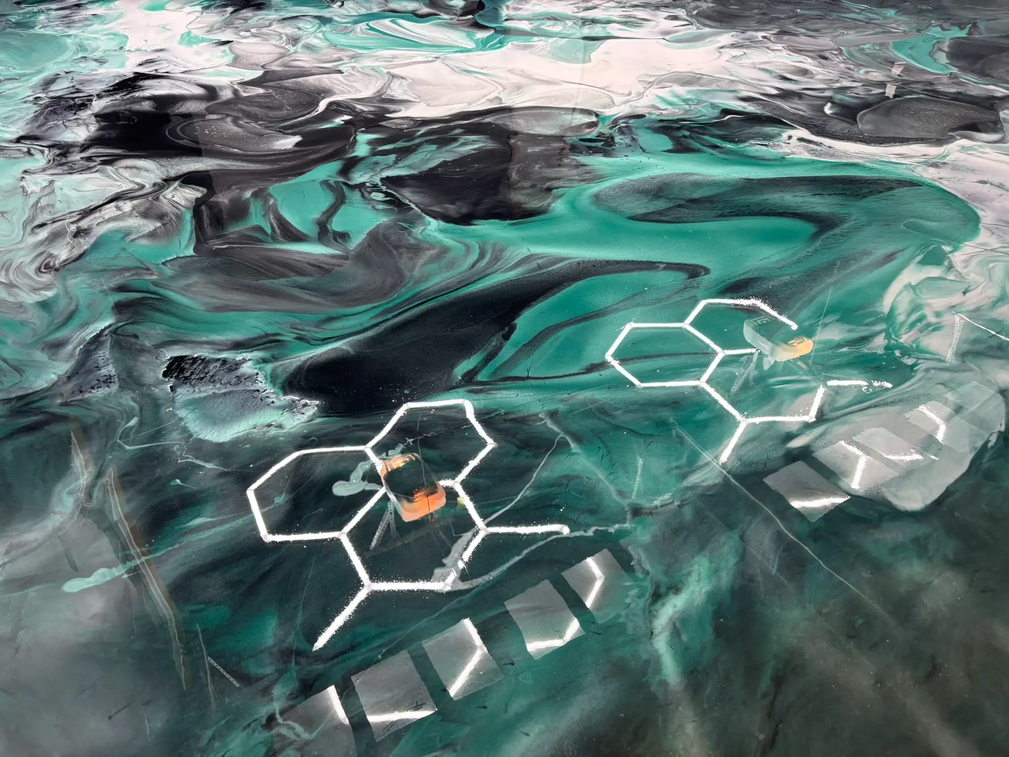 Close-up of metallic epoxy garage flooring with bold green and black marble swirl design