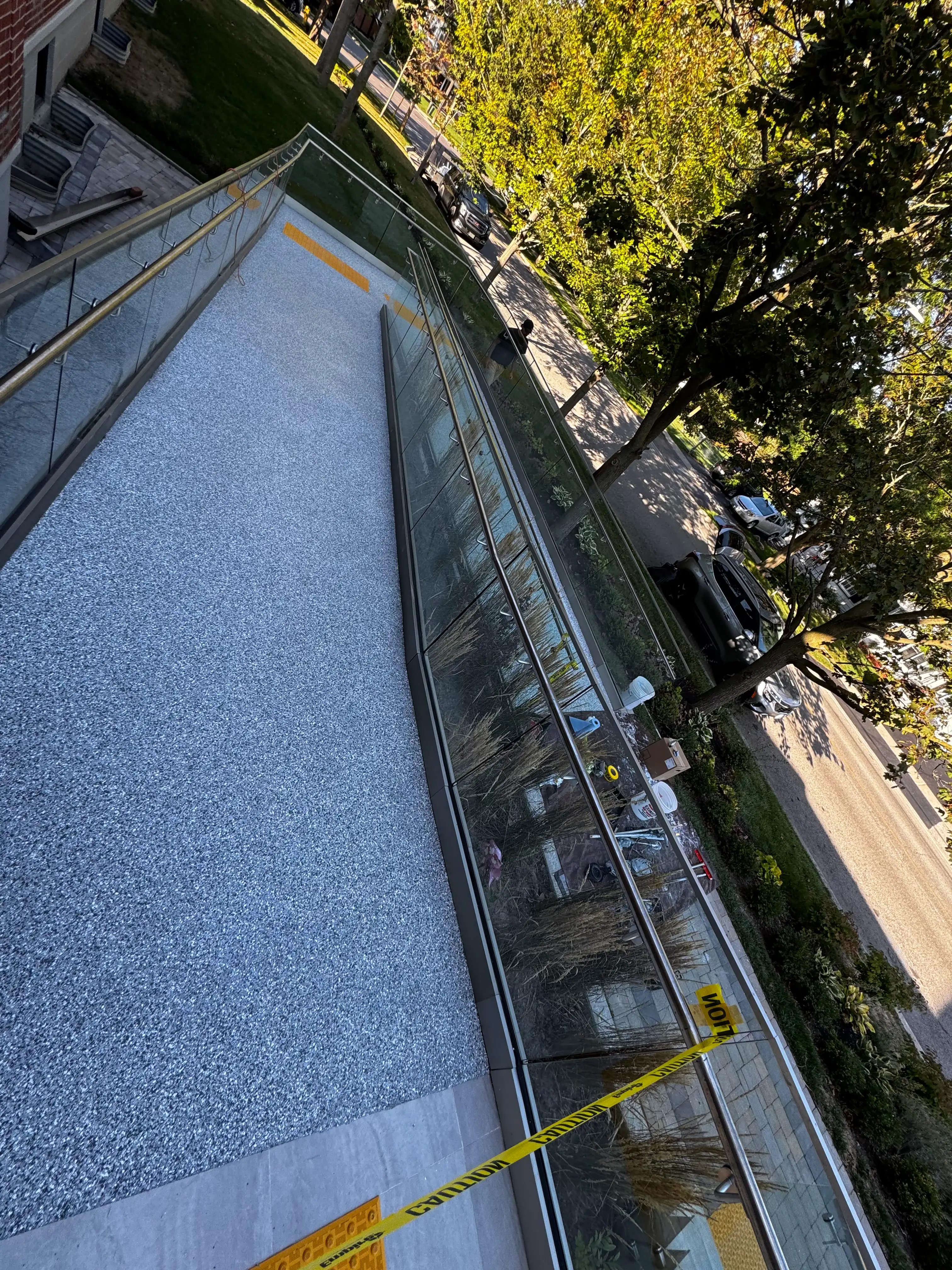 Angled view of flake epoxy wheelchair ramp with metal railings and landscaping